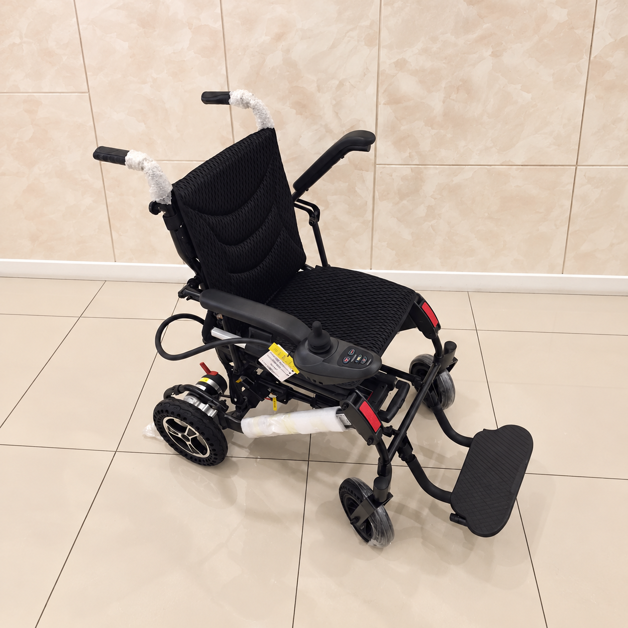 Felco DX FMEW001 electric wheelchair with black mesh seat and backrest, joystick controller on the armrest